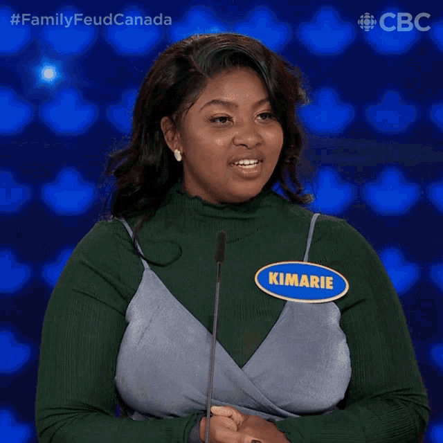 a woman stands in front of a microphone with a name tag that says kimarie