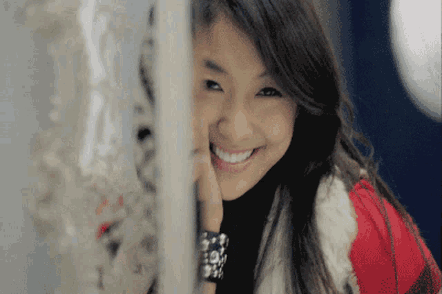 a woman wearing a fur coat and a bracelet smiles