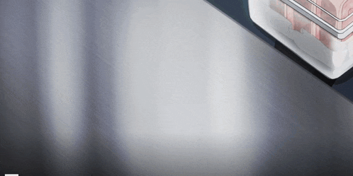 a stainless steel surface with a white container on top