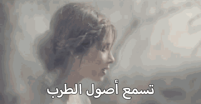 a close up of a woman 's face with arabic writing behind her
