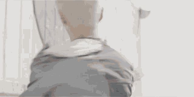a young man with white hair and a denim jacket is standing in front of a white wall .