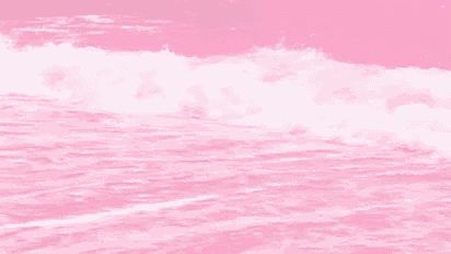 a close up of a pink ocean with waves crashing against a pink background .