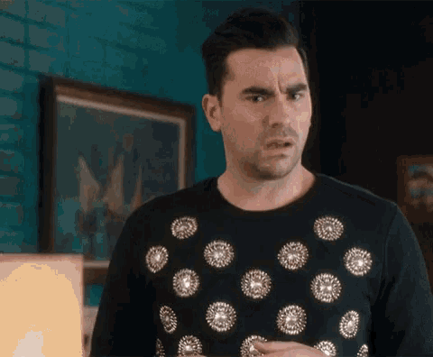 a man wearing a black sweater with silver dots on it