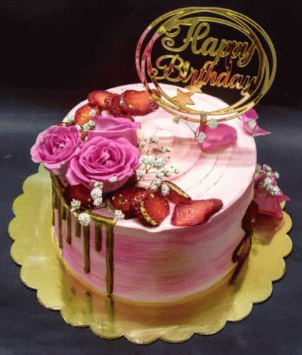 a birthday cake with pink roses and strawberries and a happy birthday sign on top