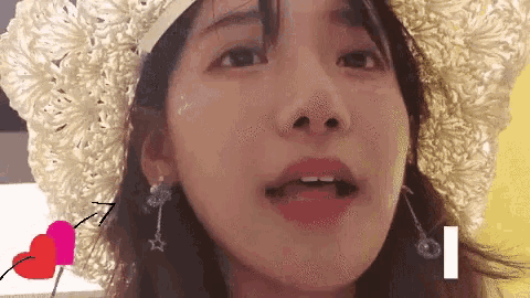 a close up of a woman wearing a hat and earrings .