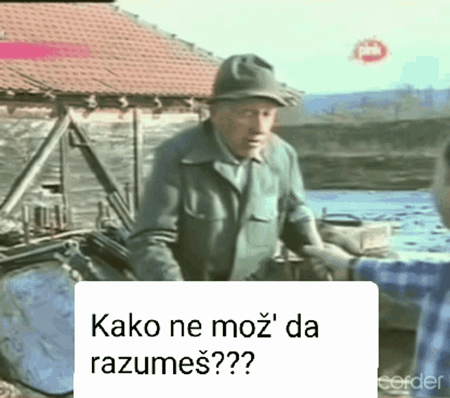 a man in a hat is talking to another man with the words kako ne moz da razumes