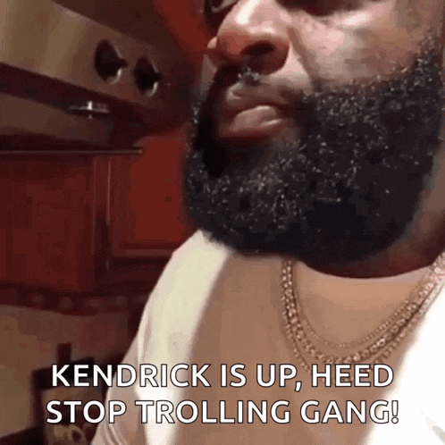 a man with a beard and a necklace says kendrick is up , heed stop trolling gang !