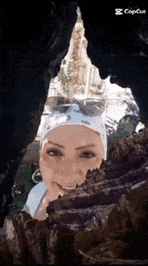 a woman wearing sunglasses and a bandana is looking out of a cave with a caption that says " capcut "