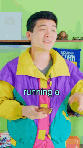 a man wearing a colorful jacket is running a phone