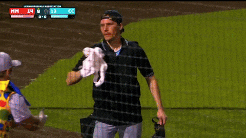 a man in a clown costume shakes hands with a baseball player in a black shirt