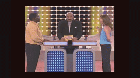 a man and a woman are standing in front of a game show host holding a card that says ' celebrity ' on it