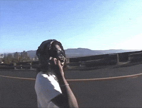 a person talking on a cell phone in front of a mountain