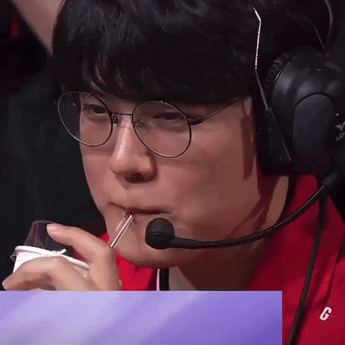 a man with glasses and headphones is drinking through a straw .