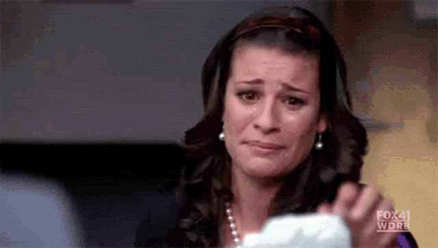 a woman is crying while holding a piece of paper that says fox 41 wdrb on it