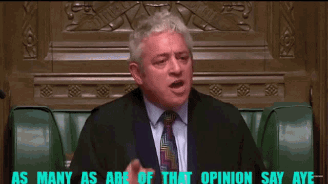 a man in a suit and tie is sitting in a chair with the words as many as are of that opinion say aye