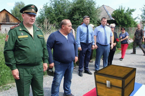 a group of men standing around a wooden chest