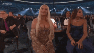 a group of women are sitting in a stadium watching a performance