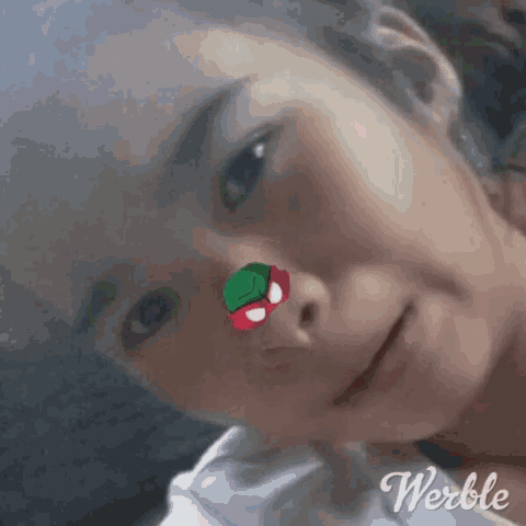 a close up of a woman 's face with a sticker on her nose .