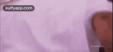 a close up of a person 's back with a purple shirt on .