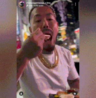a man wearing a gold chain is eating sushi