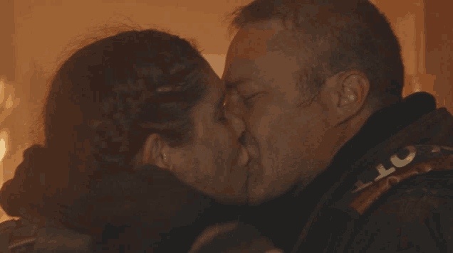 a man and a woman are kissing and the man is wearing a vest that says ' lct ' on it