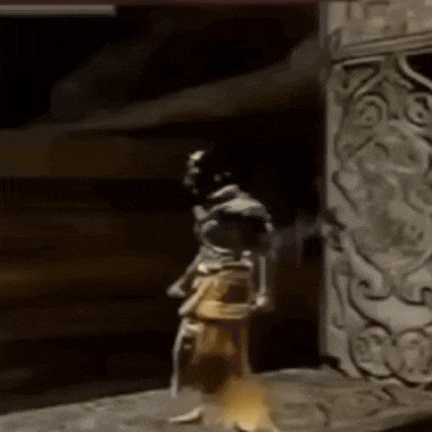 a statue of a man is dancing in a dark room in front of a stone wall .