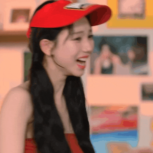 a woman wearing a red hat and a red tank top is smiling .