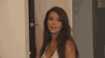 a woman with long hair is standing in front of a door .