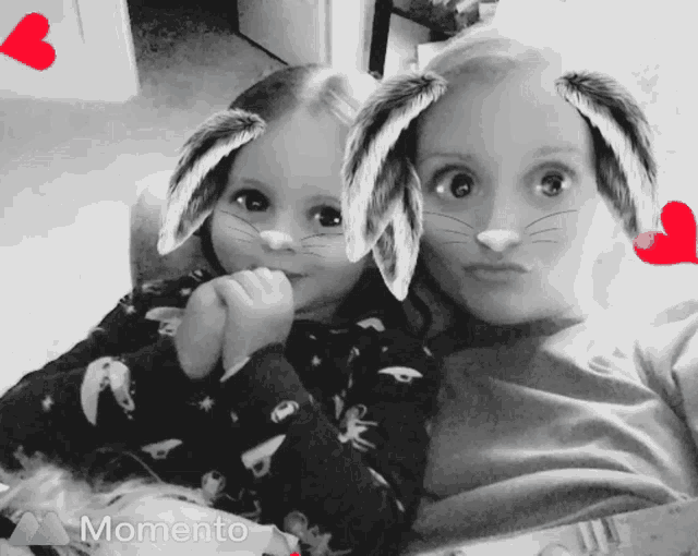 a black and white photo of two girls with bunny ears and the word momento on the bottom right