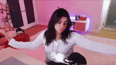 a woman sitting at a desk with her arms outstretched