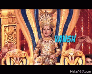 a little girl in a gold costume is sitting on a throne with the name vansh written in blue
