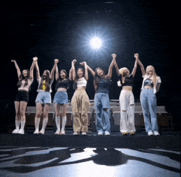 a group of girls holding hands with one wearing a shirt that says " eat "