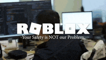a man sitting in front of a computer with the roblox logo on the top
