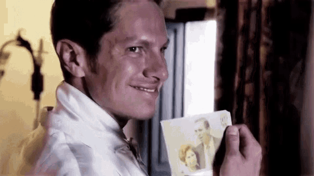 a man is holding a picture of a man and woman .