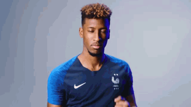 a man wearing a blue nike shirt with a rooster on the front