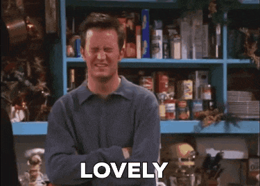a man is standing in front of a blue shelf with his arms crossed and the word lovely .