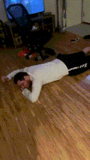 a man is laying on his stomach on the floor in front of a television