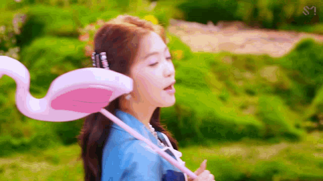 a woman is holding a pink flamingo float in her hand .
