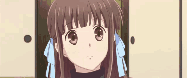 a girl with long hair and a blue bow in her hair is looking up at the camera .