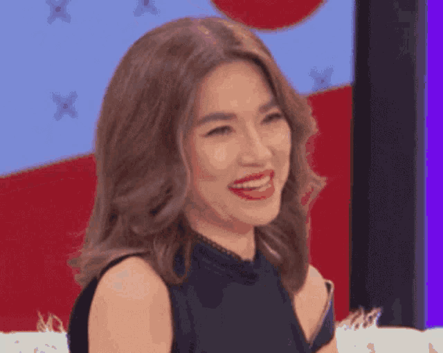 a woman in a black dress is smiling with red lipstick on her lips