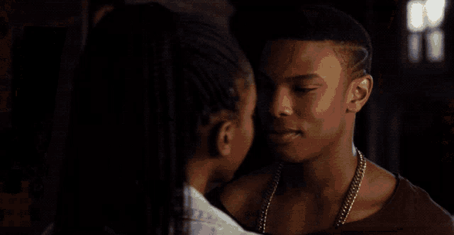 a man and a woman are kissing in a hallway