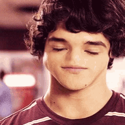 a young man with curly hair is wearing a striped shirt