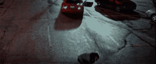 an aerial view of a person standing next to a car on a street .