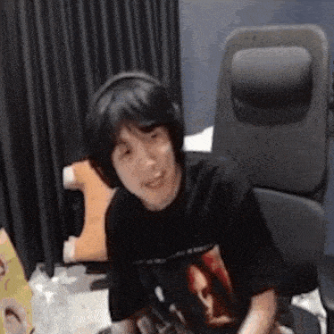 a man wearing headphones is sitting in a chair in a room .