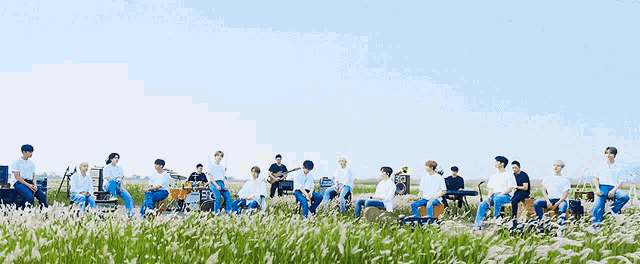 a group of people standing in a field of tall grass .