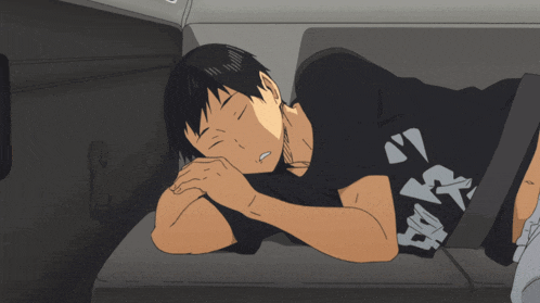 a man is sleeping in the back seat of a car wearing a black shirt with the letter a on it