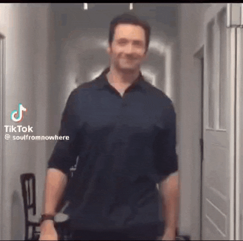 a man is standing in a hallway and smiling .