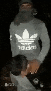 a man wearing a adidas sweatshirt is giving a woman a blowjob