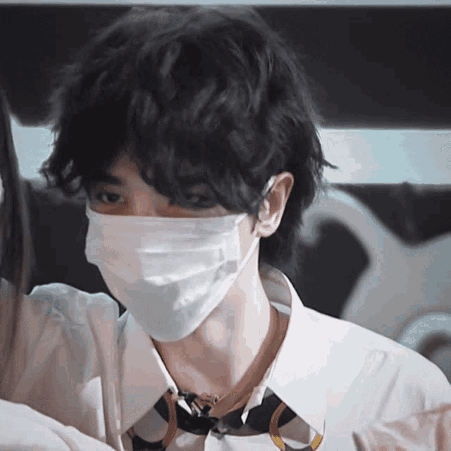 a man wearing a white shirt and tie is wearing a white face mask