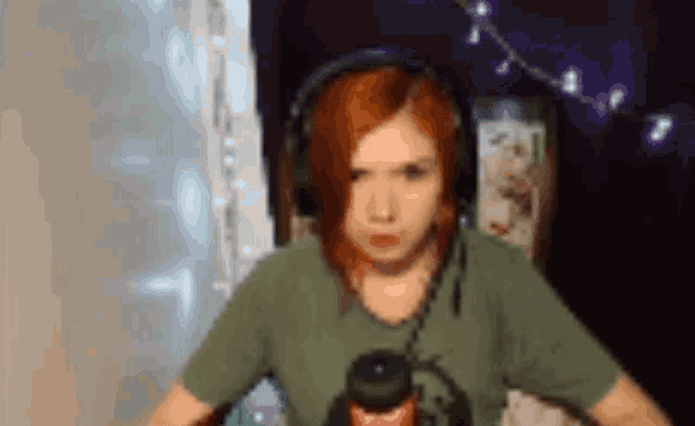 a woman with red hair is wearing headphones and a microphone .
